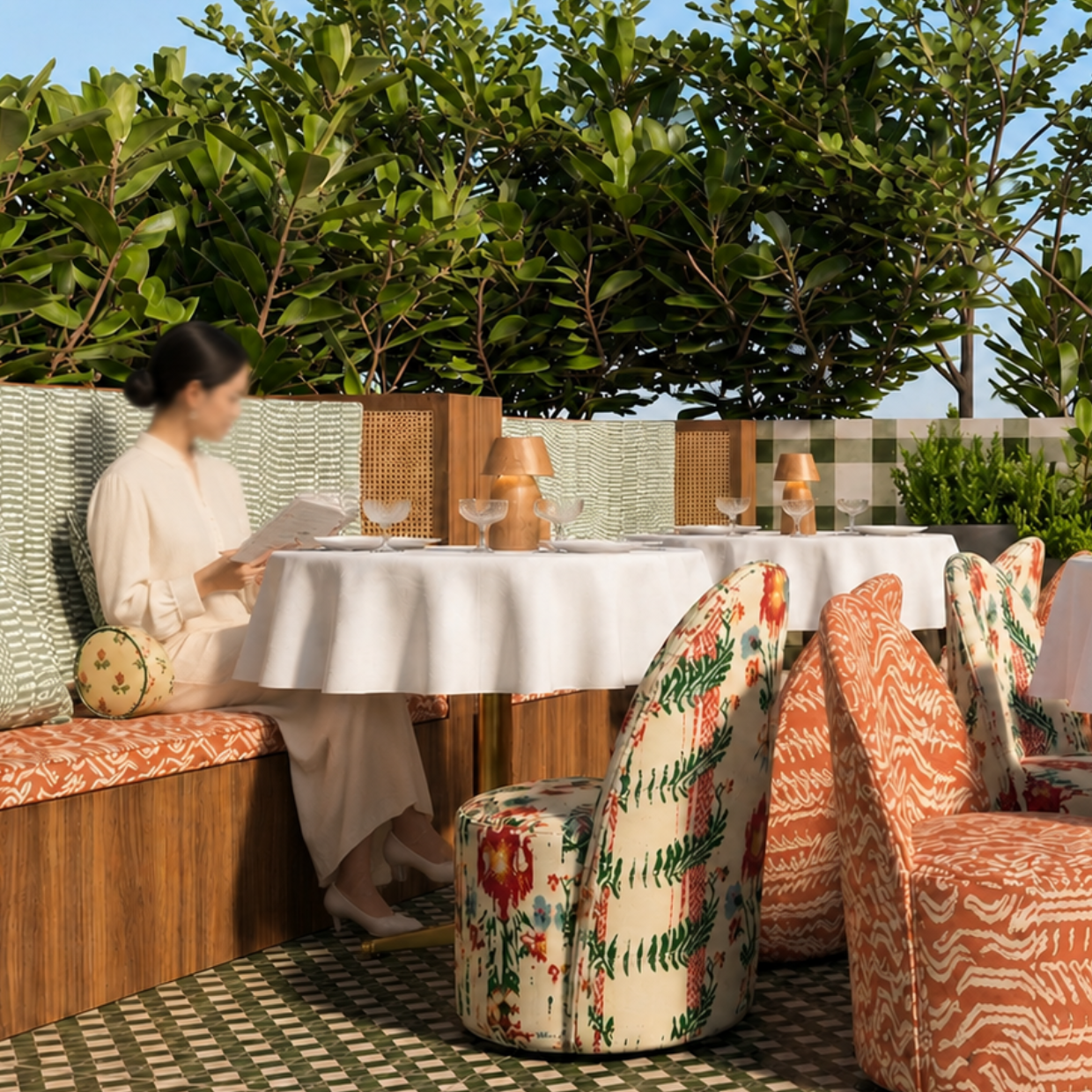 Terrasse rooftop restaurant avec fauteuils à motifs ikat orange, carrelage damier vert et blanc et cloisons en cannage – Manon le Tannou Architecte d'Intérieur